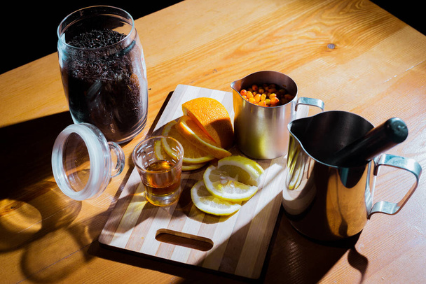 Herbata z rokitnika na drewnianym stole i sprzęcie - Zdjęcie, obraz