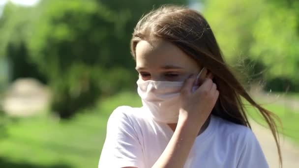 A little girl removes a medical mask after a coronavirus pandemic. - Séquence, vidéo