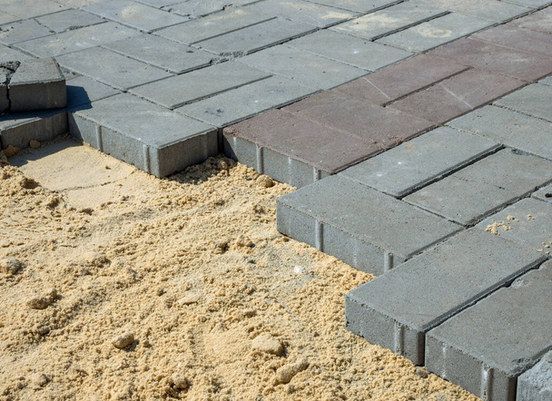 Piedras de pavimentación se encuentran en un cojín de arena
 - Foto, Imagen