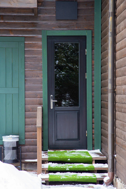 Drzwi frontowe ciemnobrązowe drewniane drzwi frontowe z oknami i winoroślami, - Zdjęcie, obraz