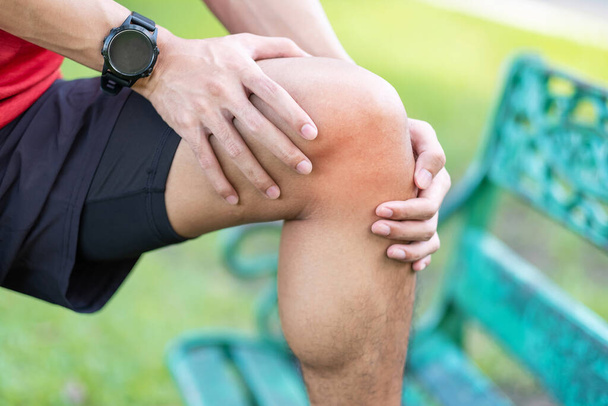 Young adult male with muscle pain during running. runner have knee ache due to Runners Knee or Patellofemoral Pain Syndrome, osteoarthritis and Patellar Tendinitis. Sports injuries and medical concept - Photo, Image