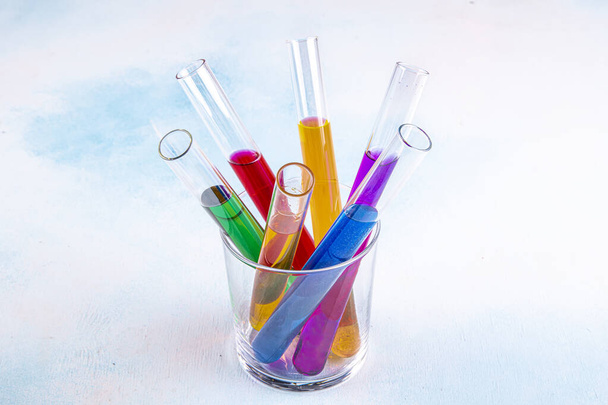 Test tubes in a rack containing rainbow colored solutions. Laboratory Equipment. - Photo, Image