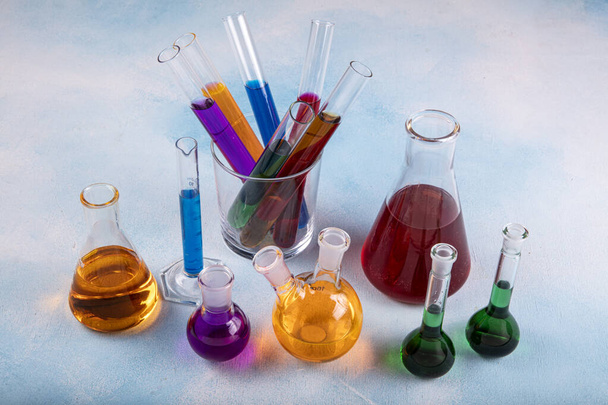 Διάφορα εργαστηριακά γυάλινα σκεύη με χρωματικό υγρό. Χημικά γυάλινα σκεύη με χρωματιστά υγρά μέσα σε φιάλες. - Φωτογραφία, εικόνα