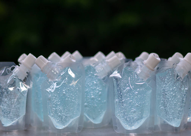 Proteção contra coronavírus: vários sabonetes de garrafa com fundo preto e uma grande quantidade de álcool gel azul. para lavar as mãos Anti-vírus e anti-bactérias e anti-vírus Covid-19. espaço de cópia
. - Foto, Imagem