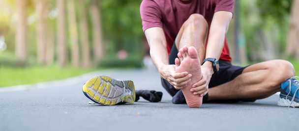 Young adult male with his muscle pain during running. runner man having leg ache due to Plantar fasciitis. Sports injuries and medical concept - Foto, imagen