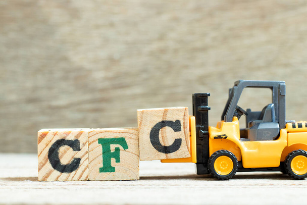 おもちゃフォークリフト単語のアルファベット文字を完了するために文字ブロックを保持単語CFC(クロロフルオロカーボンの略語)木製の背景に - 写真・画像