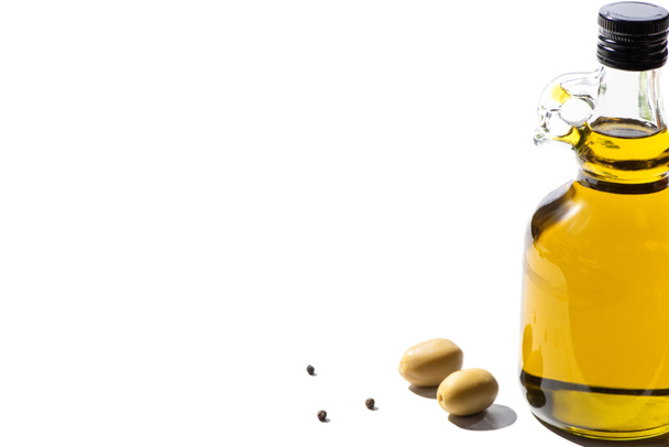 olive oil in bottle near green olives and black pepper on white background - Photo, Image