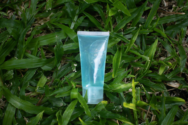 Flacone di gel alcolico blu Appoggiato sull'erba verde Gel alcolico per il lavaggio delle mani. Anti-virus e anti-batterico e anti-virus. Covid-19. copia spazio. - Foto, immagini