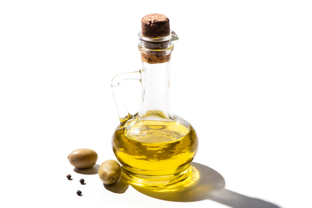 olive oil in jar near green olives and black pepper on white background - Valokuva, kuva