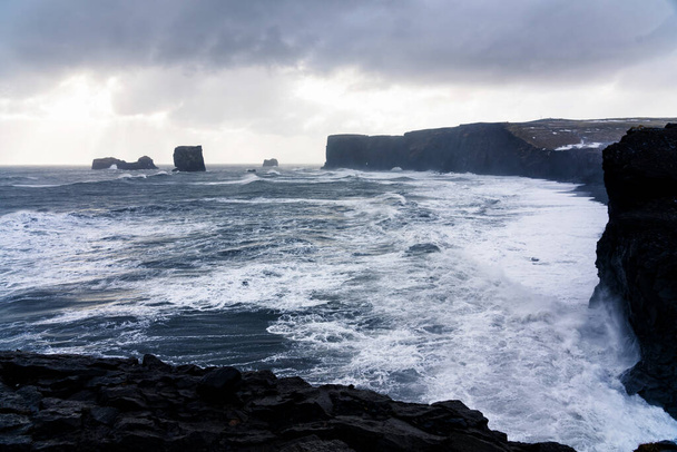 La spiaggia di sabbia nera di Reynisfjara e il monte Reynisfjall dal promontorio di Dyrholaey nella costa meridionale dell'Islanda
. - Foto, immagini