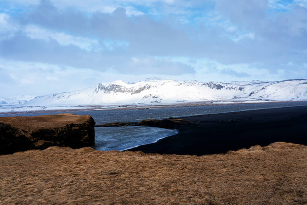Чорний піщаний пляж Рейнісфьяри і гора Рейнісфьял з хребта Дирхолай на південному узбережжі Ісландії.. - Фото, зображення