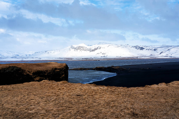 Reynisfjaran musta hiekkaranta ja Reynisfjallin vuori Dyrholeyn niemeltä Islannin etelärannikolta. - Valokuva, kuva