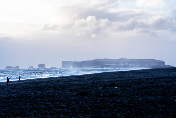 La playa de arena negra de Reynisfjara y el monte Reynisfjall desde el promontorio Dyrholaey en la costa sur de Islandia
. - Foto, Imagen