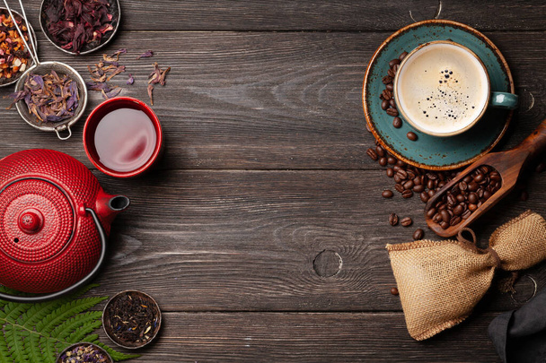 Vários chá de ervas em bule e xícara e café expresso em mesa de madeira. Vista superior com espaço de cópia. Depósito plano
 - Foto, Imagem