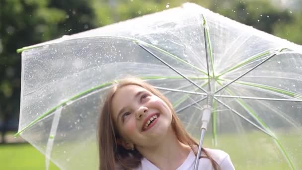 Little girl walks with a transparent umbrella in his hands - Footage, Video