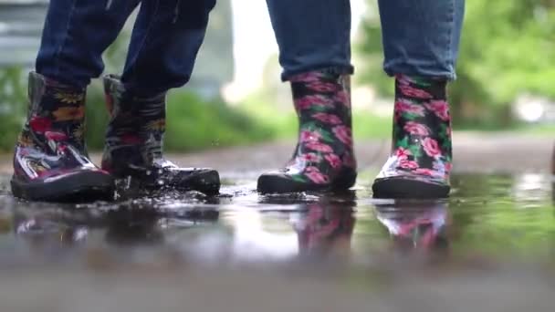 Teenagermädchen spielt nach Regen in einer Pfütze, Mutter und Tochter - Filmmaterial, Video