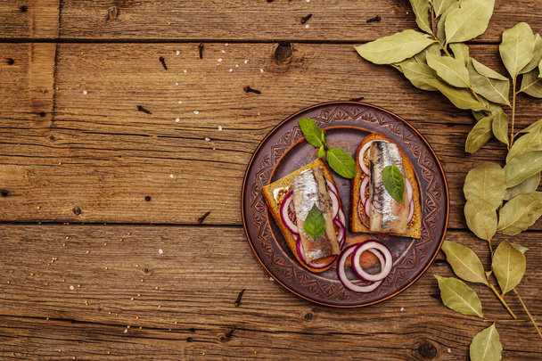 Traditional Norwegian or Danish smorrebrod. Herring sandwich, healthy eating concept. Wooden background, top view - Foto, afbeelding