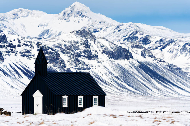 Belle vue minimaliste de l'église noire de Budir dans la péninsule de Snaefellsnes lors d'une forte tempête de neige - Photo, image