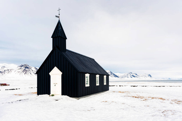 Beautiful minimalistic view of Budir black church in the Snaefellsnes peninsula during severe snowstorm - Photo, Image