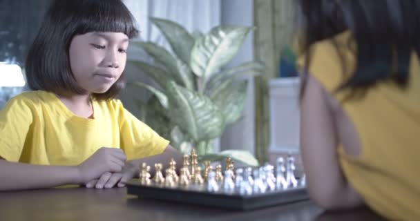 Taylandlı çocuk, Asyalı kız masada satranç oynuyor. - Video, Çekim