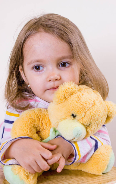Little beautiful girl and a teddy bear - Photo, Image