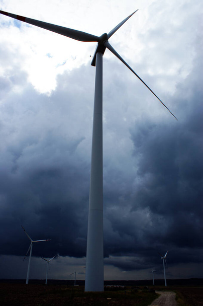 Rüzgâr çiftliği rüzgâr gülü tarlasında Bulutlu mavi gökyüzüne karşı - Fotoğraf, Görsel