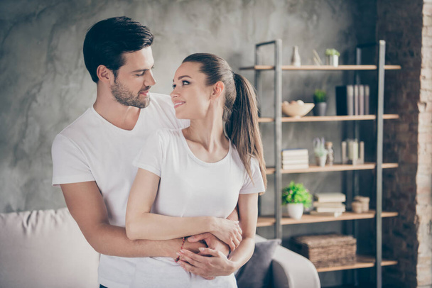 Photo of pretty charming lady handsome guy couple relaxing stand close stay home good mood quarantine hugging look eyes kissing spend time together living room indoors - Fotografie, Obrázek