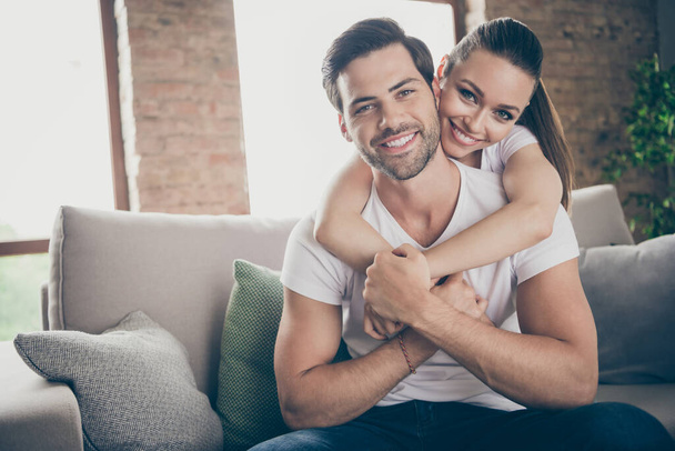 Photo of pretty charming lady handsome guy couple relaxing sit comfy couch stay home good mood quarantine hugging piggyback spend time together living room indoors - Фото, зображення