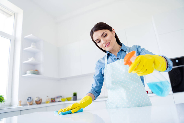 Portrait of her she nice attractive careful focused cheery housewife wiping surface cleaning wiping dusty table using antibacterial spray in modern light white interior kitchen house - Photo, Image