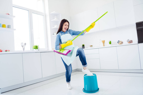 Full length body size view of her she nice attractive funny funky cheerful excited cheery housewife wiping floor playing mop like guitar having fun fooling in modern light white interior kitchen house - 写真・画像