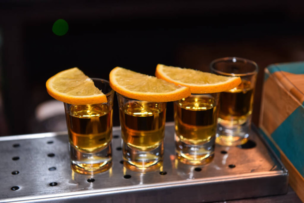 Various alcoholic shots in shot glasses in a serving tray often used for offers in the drinks industry. - Photo, image