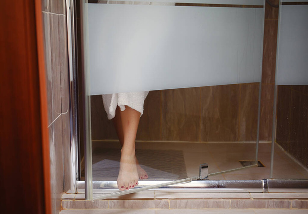 Woman emerges from shower cubicle. High quality photo - Zdjęcie, obraz