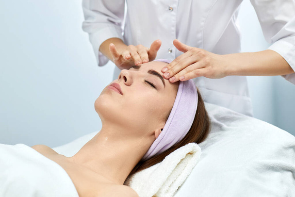 young beautiful woman receiving the facial massage - Foto, imagen