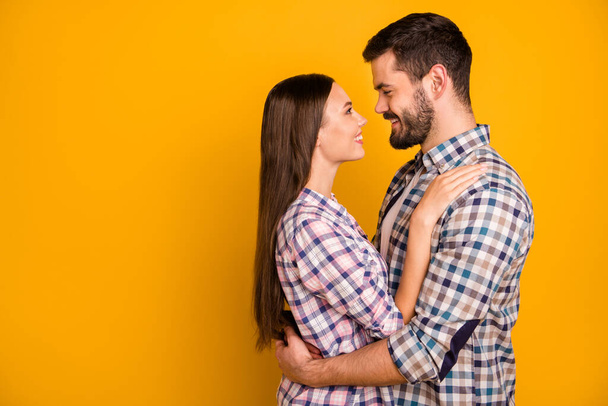 Profile photo charming lady handsome guy toothy smiling tenderness look eyes love emotions hugging stand close going to kiss wear casual plaid shirts isolated yellow color background - Foto, afbeelding