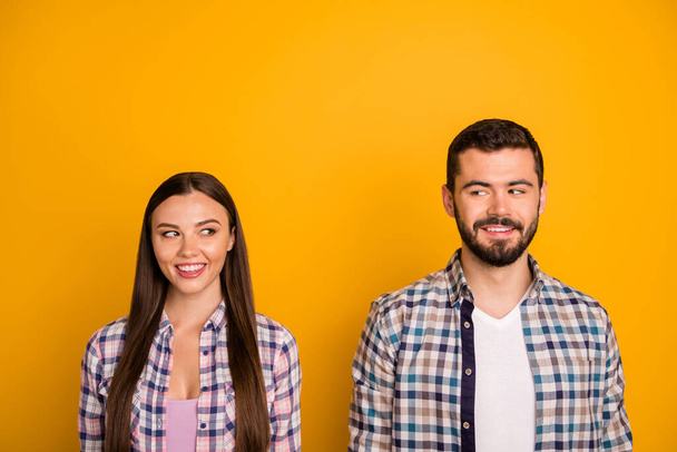 Closeup photo pretty lady handsome guy couple stand keep distance smiling look eyes tricky mood wanna touch be closer wear casual plaid shirts isolated yellow color background - Foto, afbeelding