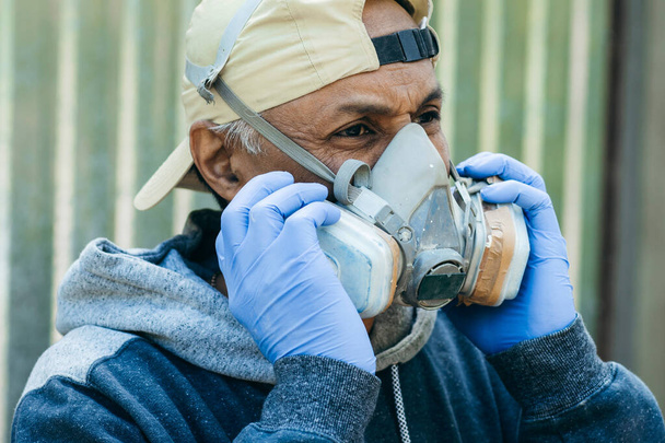 Zbliżenie portret męskiego pracownika noszącego maskę respiratora twarzy do pracy w środowisku zagrożonym.  - Zdjęcie, obraz