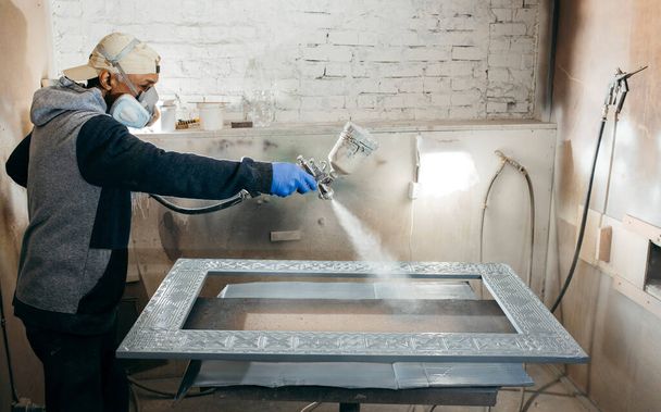 Malermeister in einer Fabrik, Industriemalerei Holz mit Spritzpistole.  - Foto, Bild