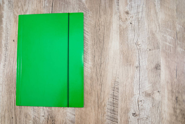 green office folder on a wooden background. Place for text. View from above. - Valokuva, kuva