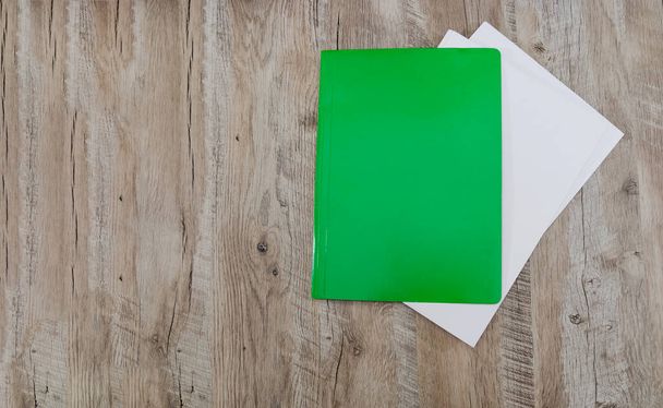 grüner Ordner für Dokumente und ein weißer Umschlag. Holz Hintergrund. Kopie des Raumes. Platz für Text. - Foto, Bild
