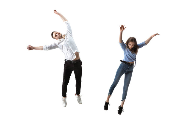 Mid-air beauty. Full length studio shot of attractive young woman and man hovering in air and keeping eyes closed - Фото, изображение