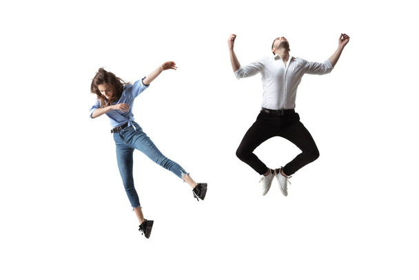 Mid-air beauty. Full length studio shot of attractive young woman and man hovering in air and keeping eyes closed - Фото, изображение