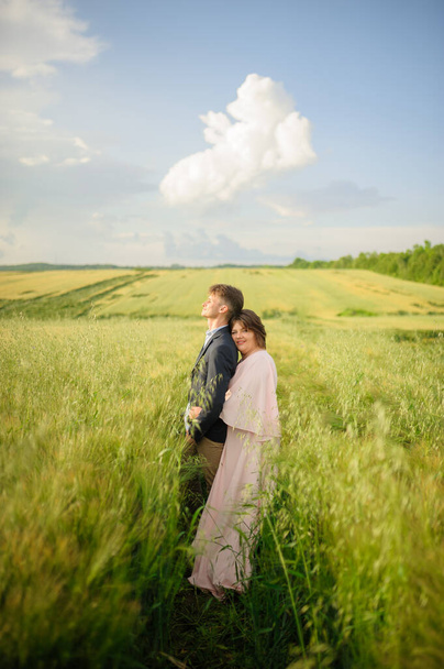 Adult couple in a green wheat field. - Fotoğraf, Görsel