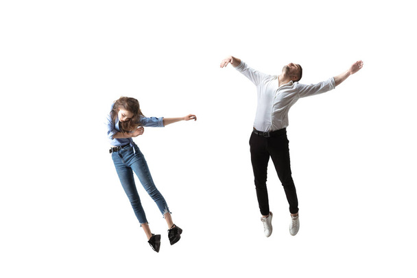 Mid-air beauty. Full length studio shot of attractive young woman and man hovering in air and keeping eyes closed - Valokuva, kuva