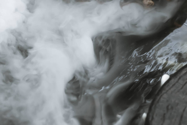 Defocused and blurred image for background. White steam,Hot Springs, Boiling and steaming water in geyser vent, Large stones arranged, Boiling water splash. closeup, vintage style. - Photo, Image