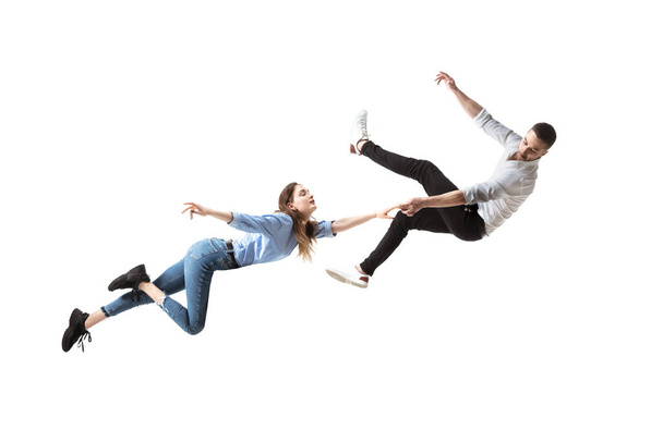 Mid-air beauty. Full length studio shot of attractive young woman and man hovering in air and keeping eyes closed - Zdjęcie, obraz