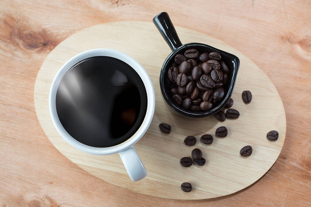 Стиль кавових крапель на столі. Гаряча кава в чашках на дерев'яному підносі. кавові зерна на столі. Дим на чашці
. - Фото, зображення