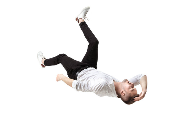 Mid-air beauty. Full length studio shot of attractive young man hovering in air and keeping eyes closed - 写真・画像