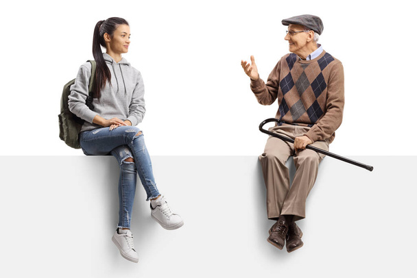 Kobieta uczeń siedzi na panelu i słucha starszego mężczyzny mówiącego izolowane na białym tle - Zdjęcie, obraz