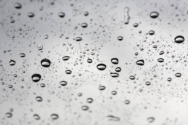 Wassertropfen. Als Hintergrund tropft Wasser auf die Glasoberfläche. Regentropfen auf Glas. Himmel im Hintergrund. Thailand. - Foto, Bild