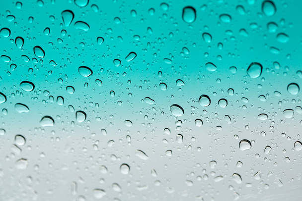水が落ちる。背景としてガラス表面に水が落ちる。ガラスに雨の滴. - 写真・画像